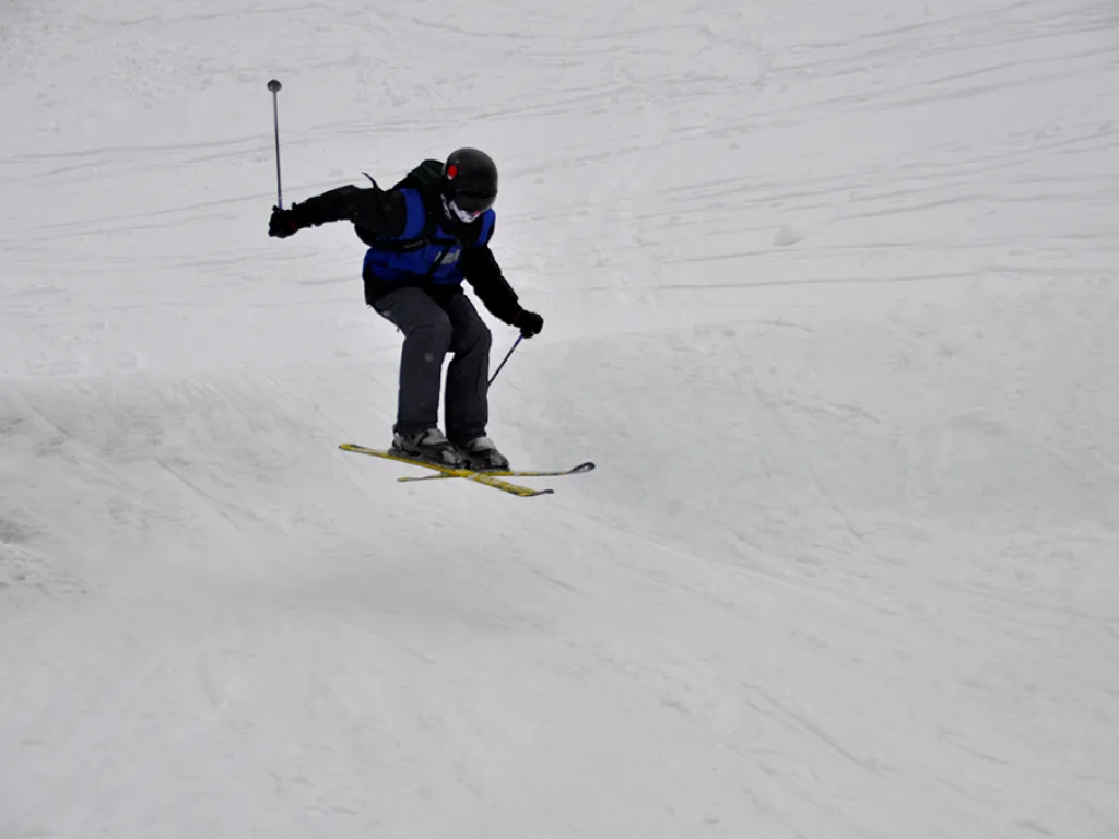 Skifahrer in tiefer Hocke auf der Piste.